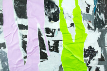 Torn And Crumpled Purple And Green Posters Glued On Billboard With Old Dirty Paper. Abstract And Creative Background Of Ripped Magazine Paper.