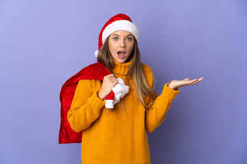 Wall Mural - Lithianian woman with christmas hat isolated on purple background with shocked facial expression