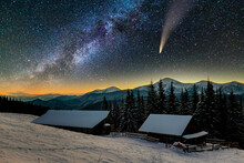 Surreal View Of Night In Mountains With Starry Dark Blue Cloudy Sky And C/2020 F3 (NEOWISE) Comet With Light Tail.