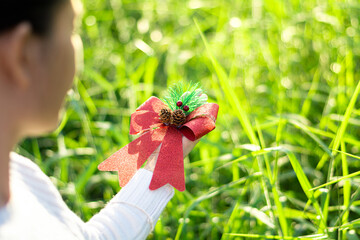 Wall Mural - Luxury red ribbon in young women hand. - Christmas gift concept.