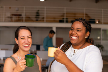 Happy black business woman laughing carefree with co-worker in business cowork space. Conversation, communication, excited, interaction concept..