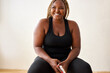© Roman - plump, plus size african american woman in black sportswear posing in studio, concept of sport, body positive, equality, people diversity