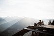 © Alex Domarco/ADDICTIVE STOCK - Side view of unrecognizable female tourist sitting at viewpoint in mountains and observing amazing scenery in morning