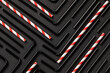 © Alex Salcedo/ADDICTIVE STOCK - Top view flat lay composition with black and withe and red plastic straws for takeaway drinks arranged in geometric ornament on black background