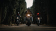 © Carlos Rodelas/ADDICTIVE STOCK - Group of bikers in black leather jackets and helmets riding powerful motorcycles on asphalt road leading between green forest in countryside