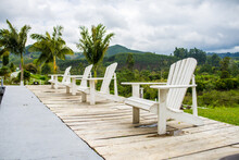 Collection Of Wooden Deck Chairs At Poolside Of Resort On Background Of Amazing Mountainous Landscape
