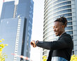 © Jose Carlos Cerdeno/ADDICTIVE STOCK - Low angle side view of positive African American male entrepreneur looking at wristwatch and checking time while standing in city and waiting for meeting