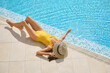 © Philippe Degroote/ADDICTIVE STOCK - From above full body of unrecognizable slim female in swimsuit and hat lying near swimming pool with clear blue water and enjoying summer holidays in resort