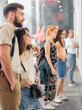 © guruXOX - Group of people in shopping mall looking new fashion clothes at shop window of a boutique. Shop sales. Black friday concept