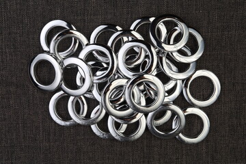 Glossy nickel-plated or chrome-plated Eyelets for attaching curtains in the design workshop.