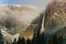 Scenic View Of Waterfall And Mountains In Fog