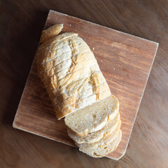 loaf of bread cut into pieces on a wooden board