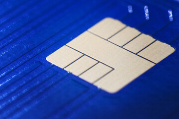 Closeup defocused view of blue plastic credit card EMV micro chip. Selective focus. Financial and Banking, Smart Payment Concept