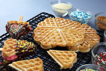 Wall Mural - Belgium waffles with chocolate sauce. popsicles with chocolate and wafer on blue background