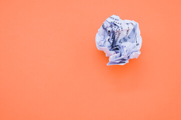 Sticker - High angle shot of a wrapped paper ball isolated on an orange background