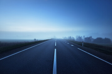 Wall Mural - Panoramic view of the empty highway through the fields in a fog at night. Moonlight, clear sky. Sunrise. Europe. Transportation, logistics, travel, road trip, freedom, driving. Rural scene