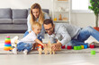 © Studio Romantic - Happy family playing with toys on floor of their living-room, enjoying quality time at home
