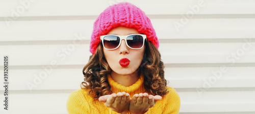Cuadros en Lienzo Winter portrait close up of young woman blowing red lips sending sweet air kiss