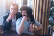 © as-artmedia - Two gay male friends hugging in a cafe, smiling and having a cigarette. LGBT and love concept.