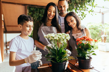 Wall Mural - Latin family taking care of the plants at home.