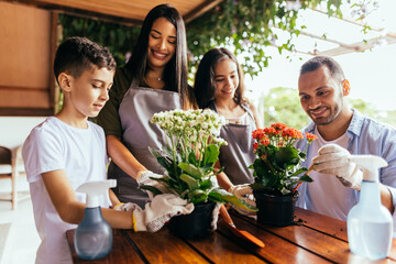 Wall Mural - Latin family taking care of the plants at home.