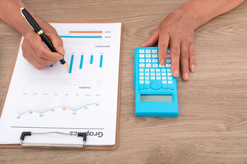 Wall Mural - Looking down and shooting financial practitioners working through documents and calculators