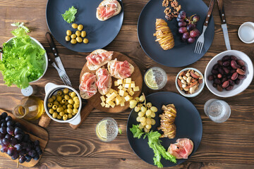 Wall Mural - Dinner table with appetizers, baked potatoes and salad top view