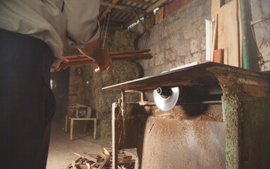 Poster - Carpenter cutting a piece of wood with a carpentry machine.