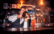 © Stop war in Ukraine! - Barman formulates a cocktail in the saloon