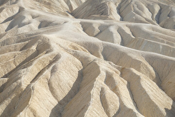 View of the lines, textures and shadows of the colorful badlands as seen from Zabriskie Point at Death Valley National Park