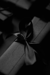 Black Christmas concept. Close up on elegant black matte wrapped gifts with ribbon.