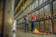 © zinkevych - Two men in orange helmets talking in the warehouse
