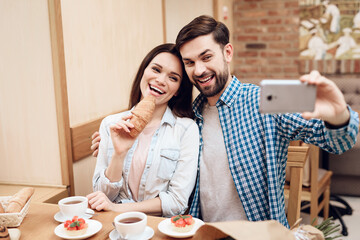 Wall Mural - Young Couple Taking Selfie on Smartphone Cafeteria