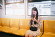 © Have a nice day  - Beautiful Asian Business woman using mobile smart phone Technology contact communication in public area commuter transport city life traveling to work through train station business travel copy space
