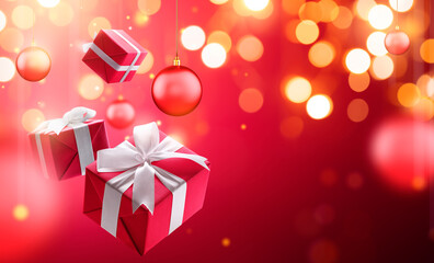 Wall Mural - Christmas gifts with hanging bauble over blurred bokeh light background