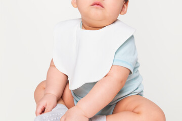 Baby wearing white apron in studio