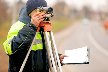 Professional engineer surveyor making measure with tacheometer theodolite before startup construction works