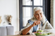 Modern grandmother eating fresh green salad