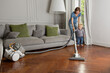 © Lisa Tichané - Cute toddler helping mother vacuum hardwood floor in living room