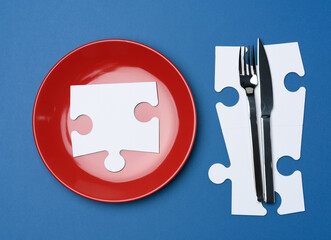 Wall Mural - red round ceramic plates, fork with knife on a blue background