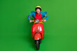 Full size photo of young beautiful excited crazy smiling girl ride fast red motorcycle isolated on green color background
