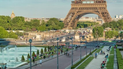 Wall Mural - Sunset view of Eiffel Tower timelapse with fountain in Jardins du Trocadero in Paris, France. Long shadows. People walking around. Eiffel Tower is one of the most iconic landmarks of Paris.