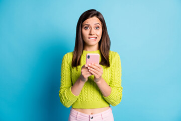 Sticker - Photo of young girl afraid nervous panic fail problem bite lips type cellphone isolated over blue color background