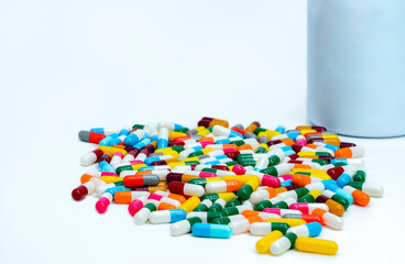 Sticker - Colorful capsule pills near plastic drug bottle. Multi-colored capsule pills on white table. Pharmacy drugstore products. Pharmaceutical industry. Health budget and policy. Bright colors capsule pills