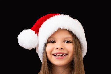  A beautiful girl smiles in a Christmas hat.