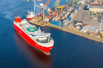 Wall Mural - Cargo red ship with helipadfor the transport of cars and other new transport sails from the port to the sea, flight aerial top view.