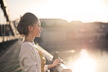 Wall Mural - young woman watches the sunset from the chain bridge in budapest