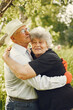 © prostooleh - Adult couple in a summer garden. Handsome senior in a white shirt. Woman in a black blouse.