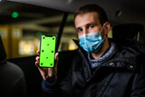 Fototapeta  - Young passenger showing something on his phone during coronavirus pandemic