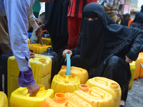 Fotomural A Yemeni woman fetching water due to the water crisis in Taiz